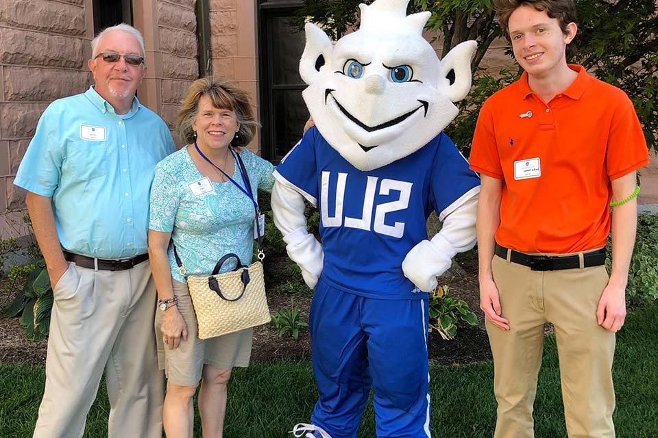 Three members of the Fister family pose with the Billiken.